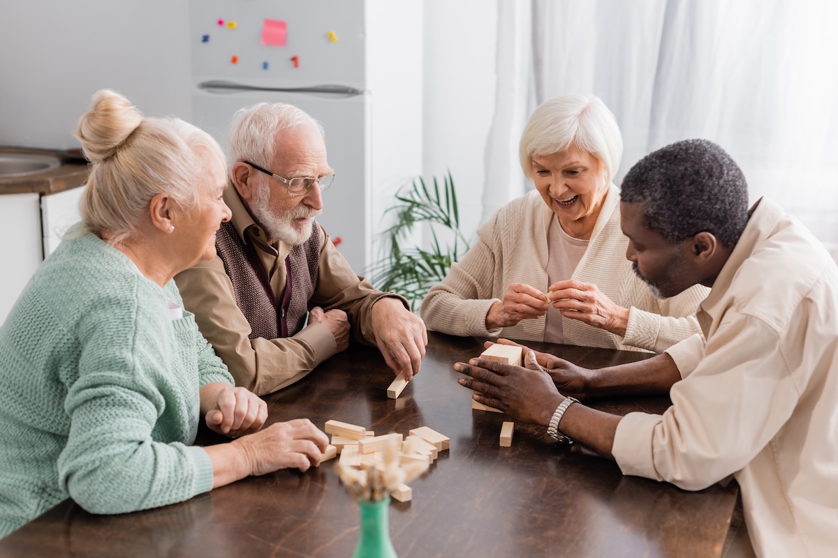 Excited,Senior,Woman,Smiling,While,Playing,Tower,Wood,Blocks,Game